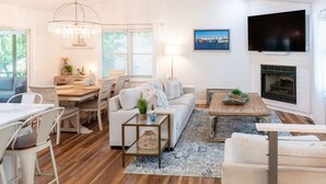 Ein modernes Wohnzimmer mit Essbereich, Kamin und Fernseher.
