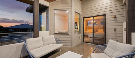 A modern outdoor living space with a sofa, chairs, and a table.