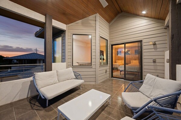 A modern outdoor living space with a sofa, chairs, and a table.