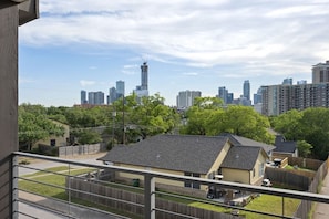 A residential area with a view of a city skyline, including high-rise buildings and a construction crane.