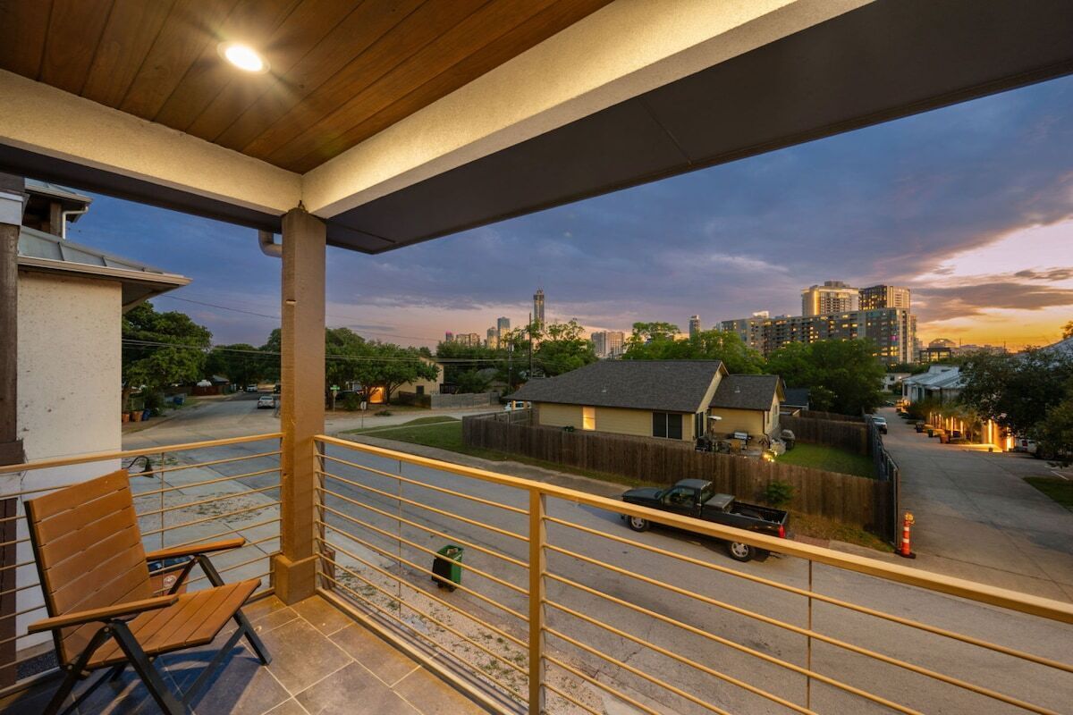 A balcony with a view of a cityscape at dusk.
