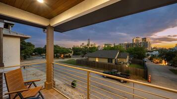 A balcony with a view of a cityscape at dusk.
