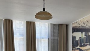 Ein modernes Wohnzimmer mit einer Couch, einem Couchtisch und einem großen Fenster mit Vorhängen.