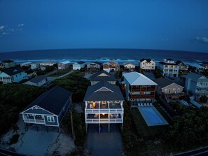 Un quartier résidentiel situé sur la côte, avec des maisons, une piscine et une vue sur l’océan.
