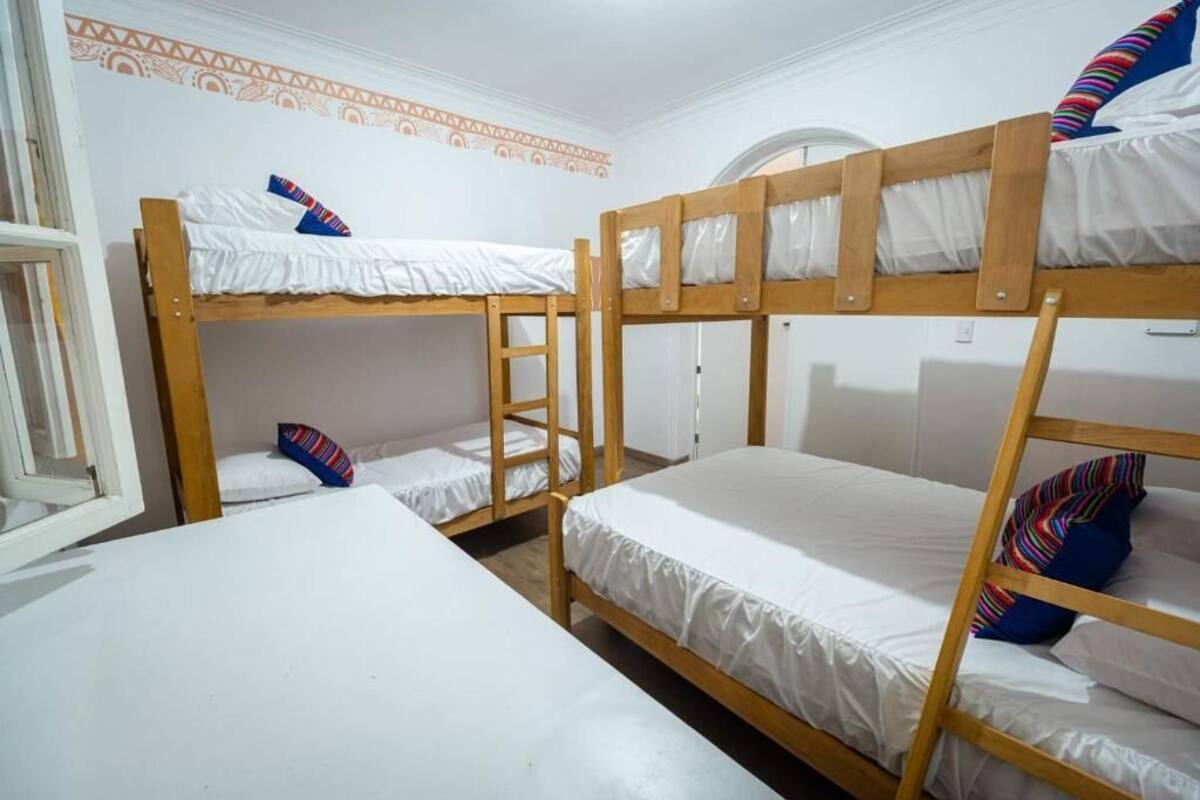 Una camera del dormitorio con letti a castello, una scala e una finestra.