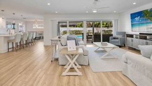 A modern living room with a sofa, coffee table, and dining area.