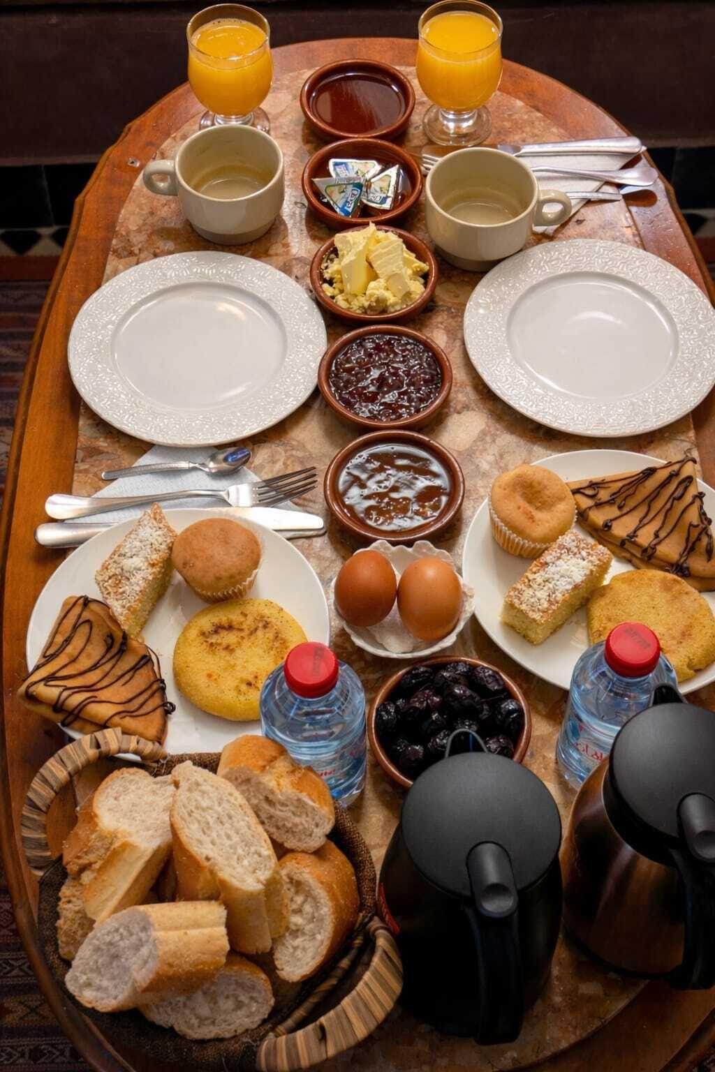 Un vassoio della colazione con cibi, bevande e utensili.