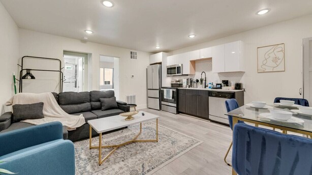 A modern apartment with a living room, dining area, and kitchen. - Stylish City Getaway | Near Deep Ellum & Downtown (Dallas)