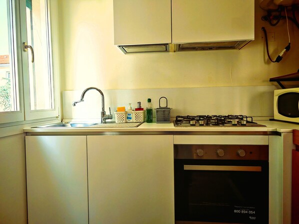 A compact kitchen with a sink, stove, and oven.