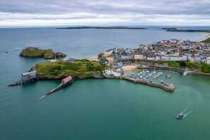 A coastal town with a marina, colorful buildings, and a historic fort on a small island. - Tenby Studio Apartment - Stroll to Beach and Town (Tenby)