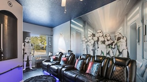 Een kamer met een Star Wars muurschildering, leren banken en een Stormtrooper figuur.