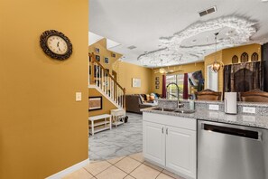 A kitchen with white cabinets, a stainless steel dishwasher, and a granite countertop.