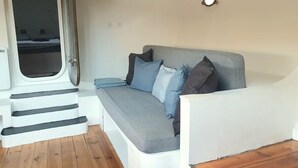A compact living space with a sofa, pillows, a window, and a door.