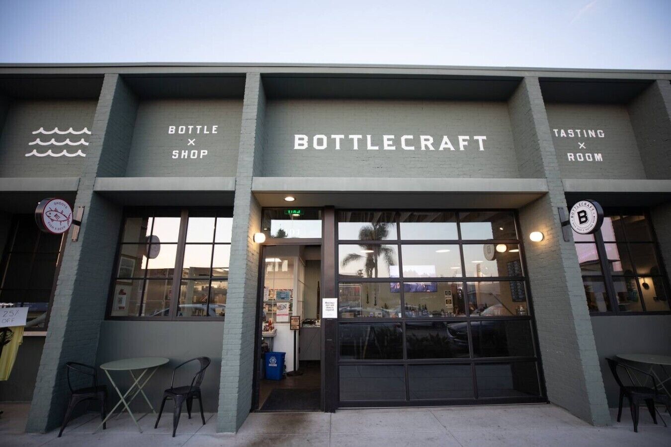 A building with a storefront labeled 'BOTTLECRAFT' and a sign indicating a 'TASTING ROOM' on the right.