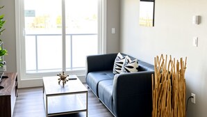 Ein modernes Wohnzimmer mit einer Couch, einem Couchtisch und dekorativen Zweigen.