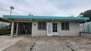 A single-story building with a flat roof, a satellite dish, and a small porch.