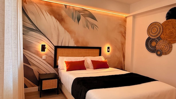 Una camera da letto moderna con un letto grande, due comodini, un murale e decorazioni murali.