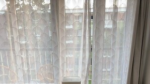 Un salon comprenant une table ronde en verre, un canapé, un fauteuil et un radiateur portatif.