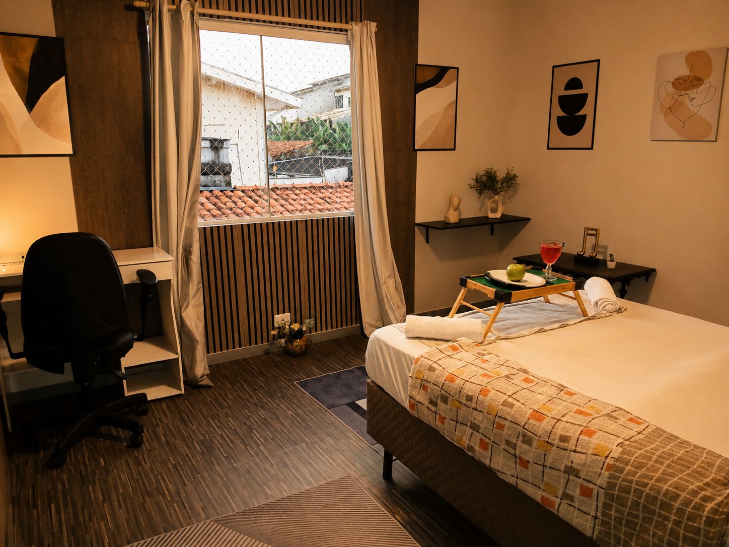 Una habitación de hotel con cama, escritorio, silla y vistas al exterior.
