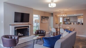 A modern living room with a fireplace, leather armchairs, a sofa, and a flat-screen TV. - 3BR The Montrose Collective D, Walk to Food & Fun! ★★★★★ (Houston)
