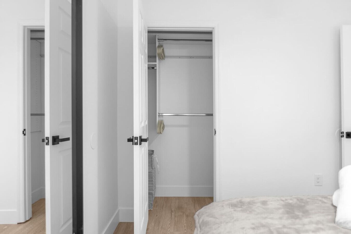 A bedroom with a bed, a closet, and an open door leading to another room.
