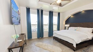 Un dormitorio con cama, escritorio, silla y televisor.