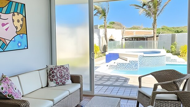A modern living room with a glass door leading to a pool area. - Casa de playa a 4 cuadras del mar (Puerto Colombia)
