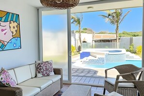 Ein modernes Wohnzimmer mit Glastür zum Poolbereich.