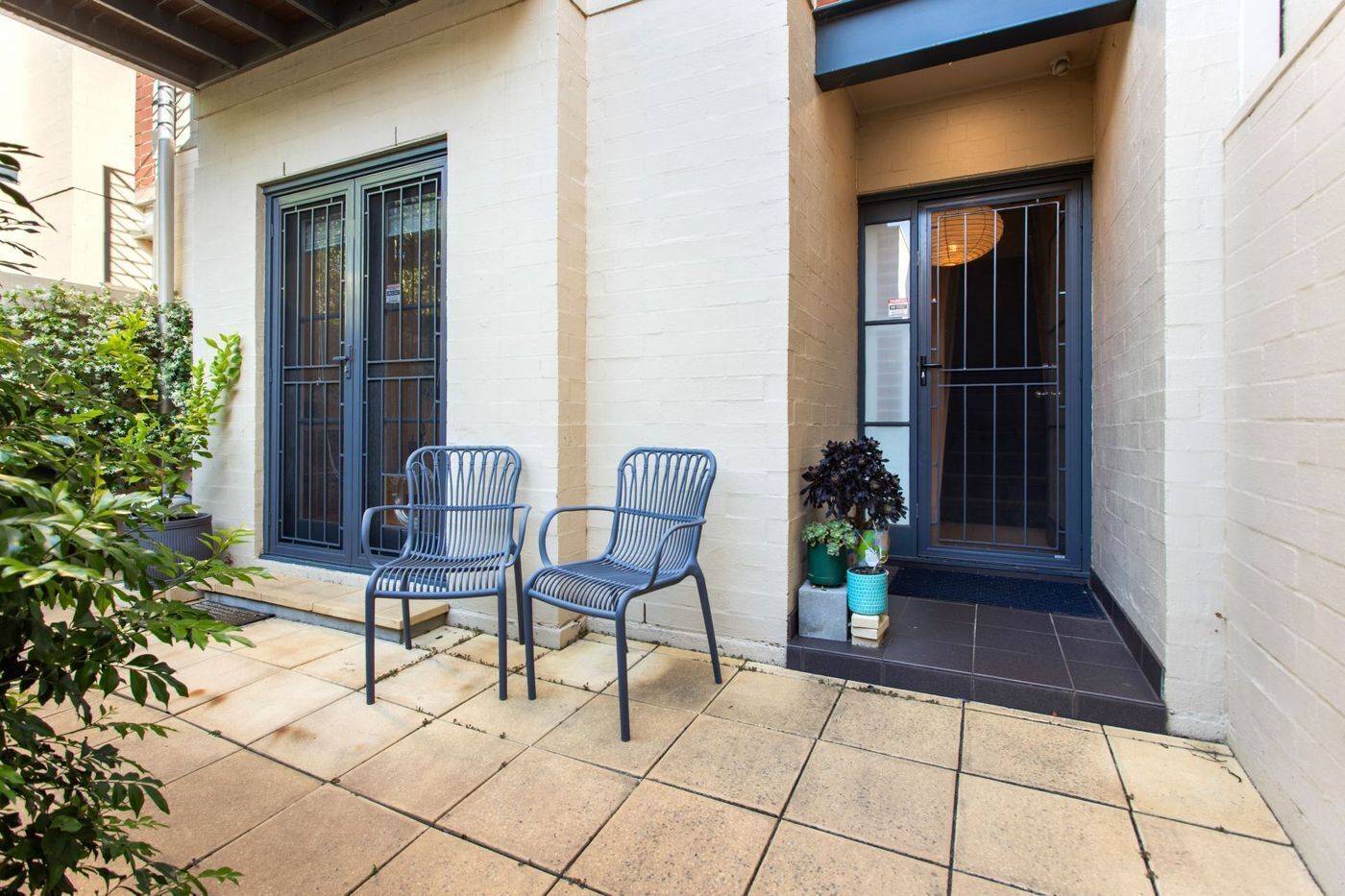 Un espace patio avec deux chaises et une plante en pot.