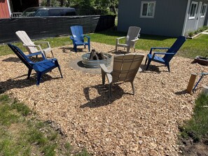 A backyard with outdoor seating and a fire pit.