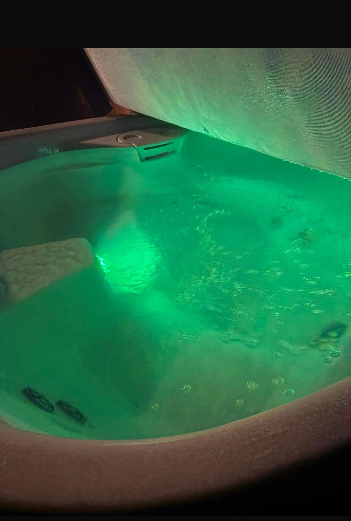 Un jacuzzi avec un éclairage vert.