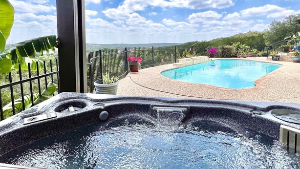 Un jacuzzi con piscina y vistas a un paisaje montañoso.