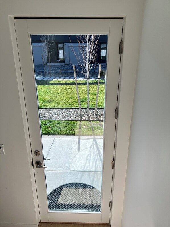 A white door with a glass panel, a metal handle, and a peephole. - Charming fully furnished new studio, Downtown Sacramento (Sacramento)