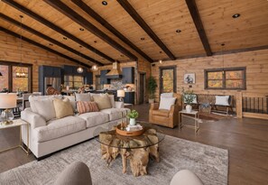 A spacious living room with a large sofa, a coffee table, and a fireplace. - Sippin on Sunsets: Ultra Luxe Escape • Epic Views • Hot-Tub • Secluded Comfort (Cherry Log)