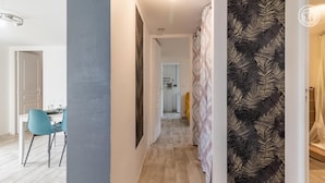 A hallway with a wooden floor, a dining area with a table and chairs, and a kitchen in the background. - VILLA MASANDJO - SAINT ALBAN LEYSSE (SAINT ALBAN LEYSSE)