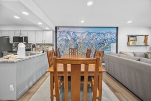 A modern kitchen with white cabinets, a stainless steel refrigerator, and a microwave.