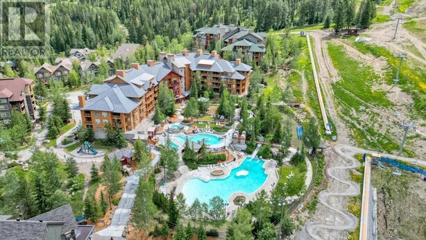 Ein Resort mit mehreren Gebäuden, einem zentralen Schwimmbad und einer Seilbahn.