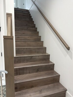 Eine Holztreppe mit Handlauf, die zu einer oberen Etage führt.