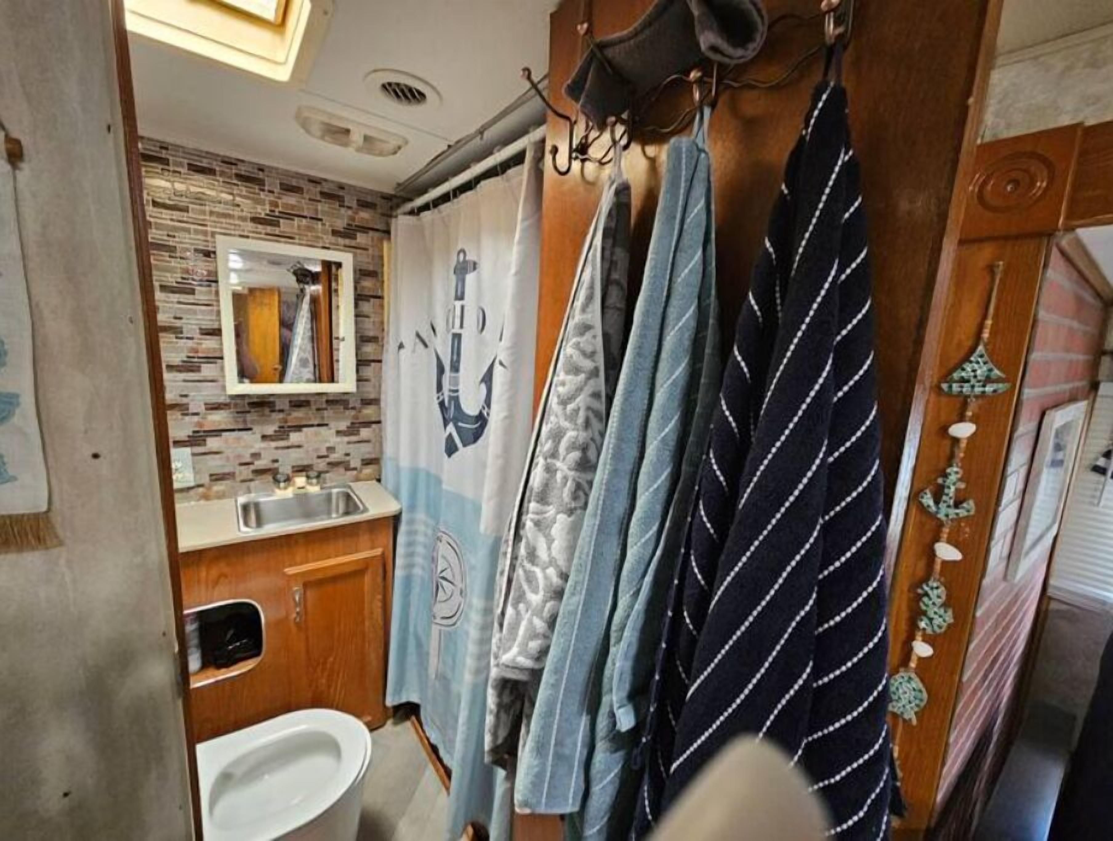 Une petite salle de bain avec un mur recouvert de carreaux derrière le lavabo, un lavabo et un miroir.
