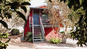 A red building with a staircase leading to a balcony.