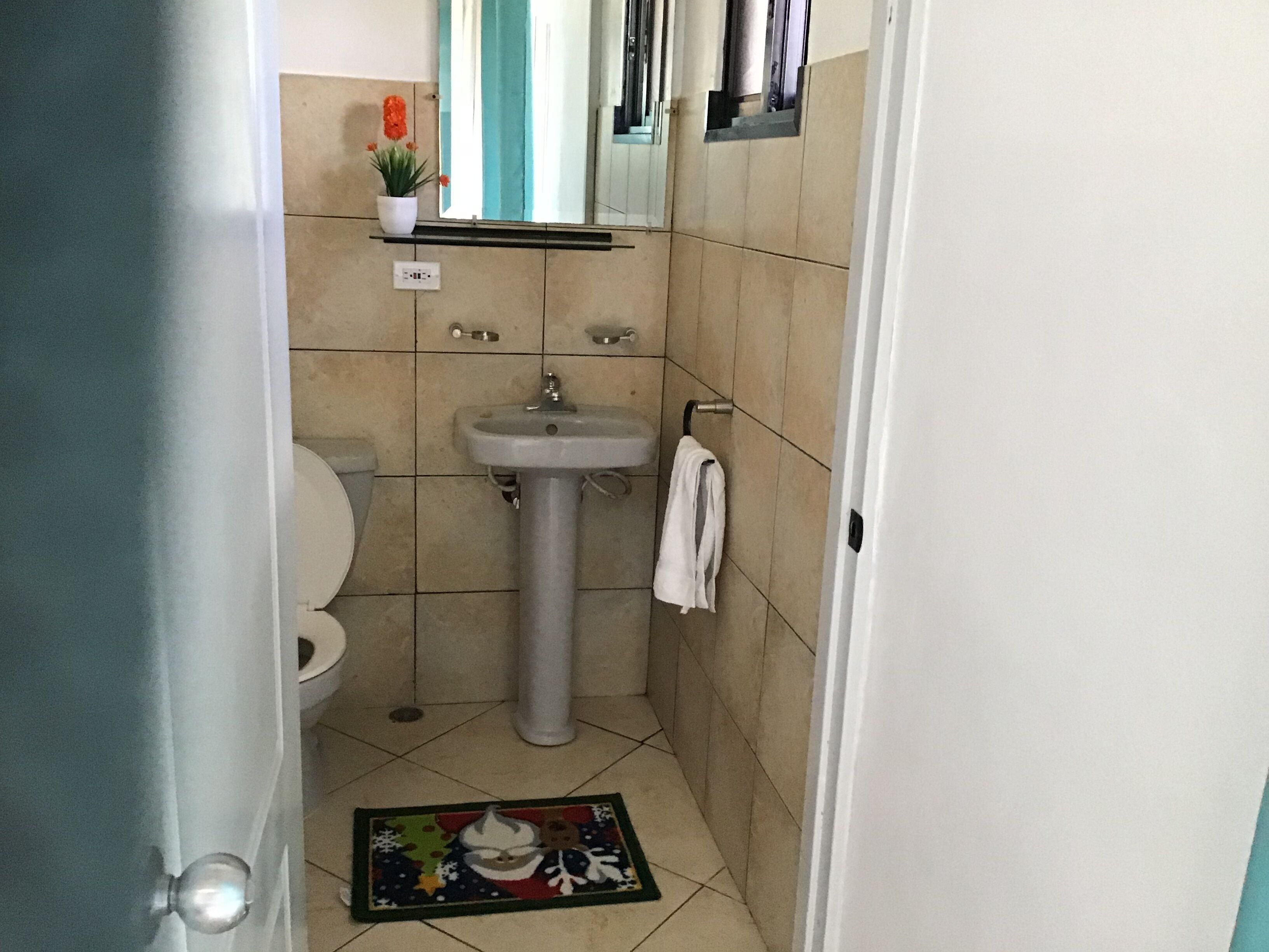 A small bathroom with a sink, toilet, and a mirror above the sink.