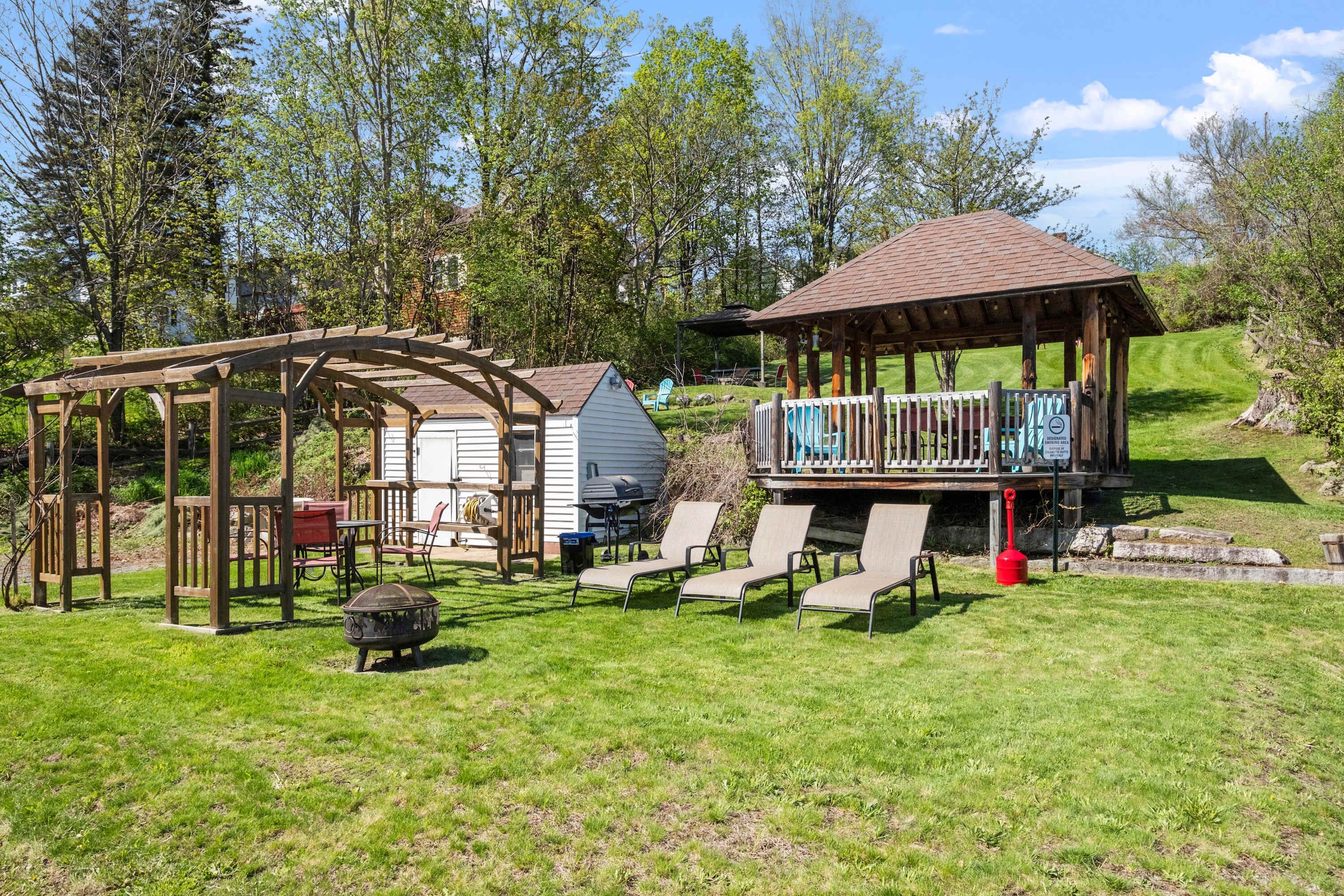 The shared outdoor space offers fire pits, loungers, and a peaceful lawn perfect for games or picnics.