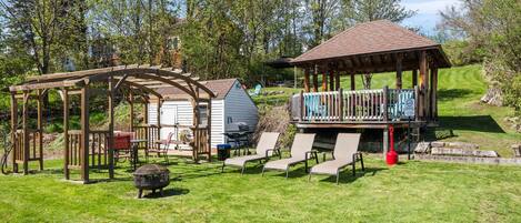 The shared outdoor space offers fire pits, loungers, and a peaceful lawn perfect for games or picnics.
