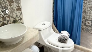 Un baño con lavamanos blanco, inodoro y cortina de ducha azul.