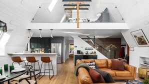 A modern loft apartment with a kitchen, dining area, and living space.