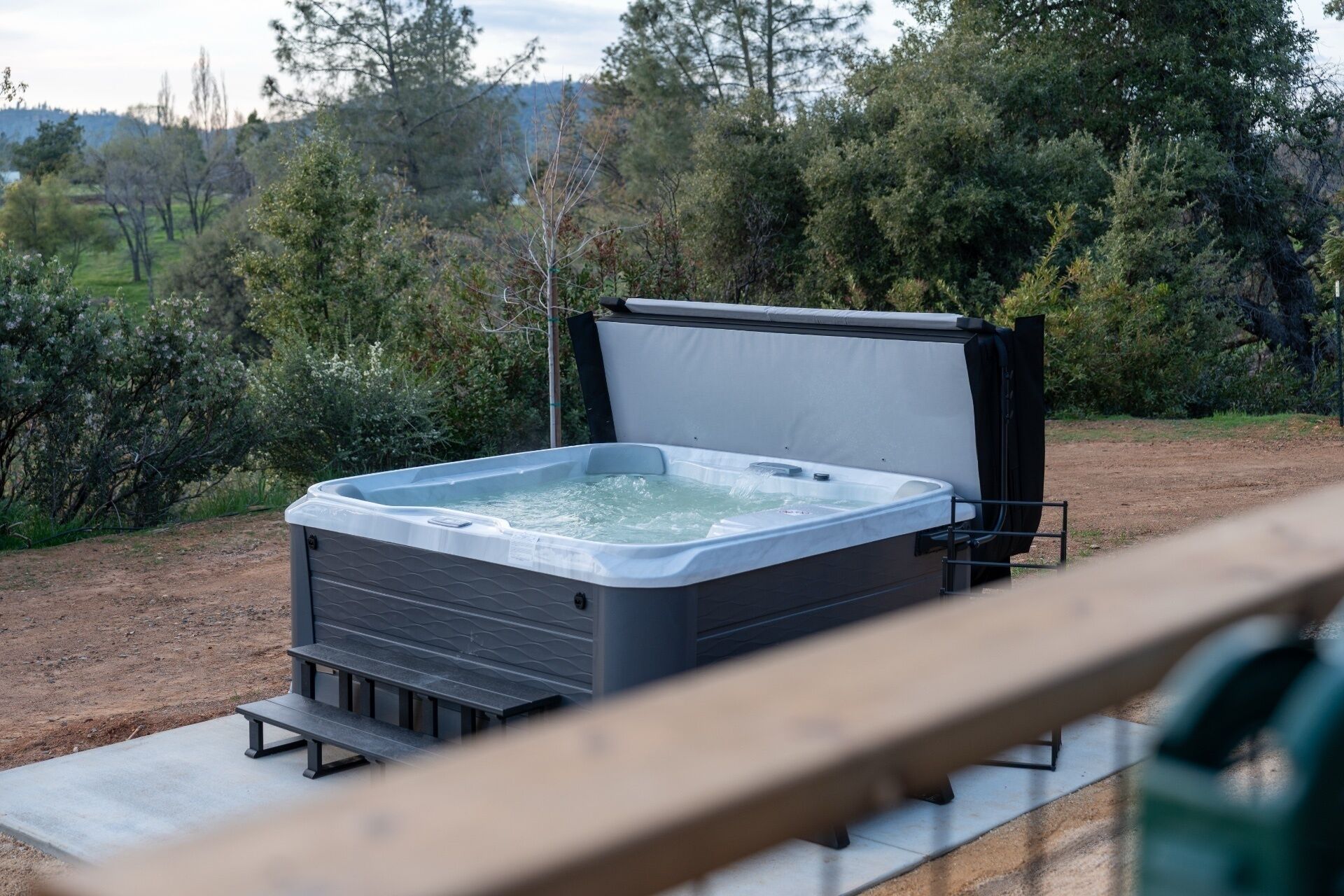 Un jacuzzi con tapa, situado sobre una plataforma de hormigón al aire libre.