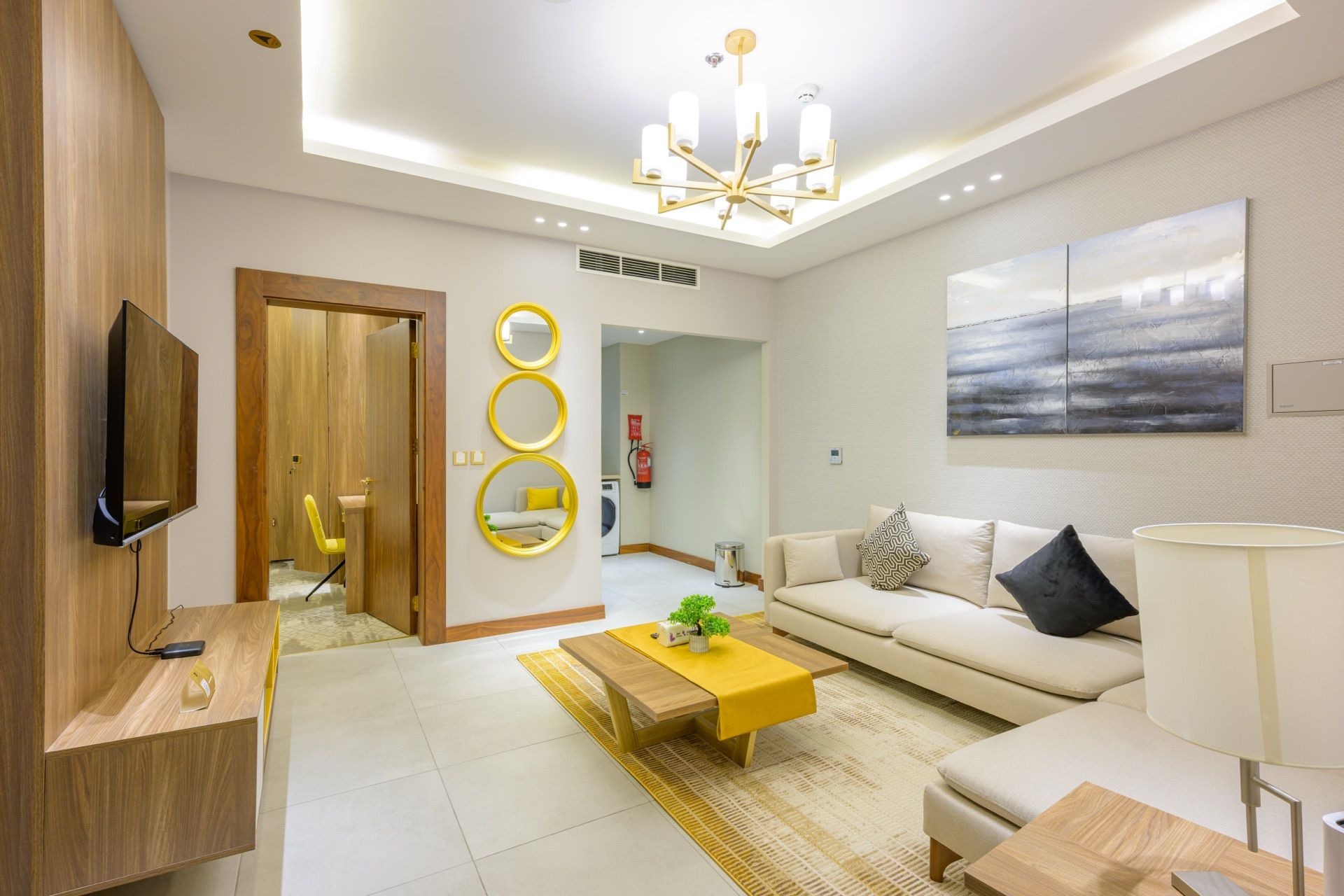A modern living room with a sofa, coffee table, and a flat-screen TV mounted on a wooden wall.