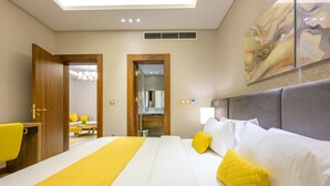 Habitació d'hotel amb un llit, un escriptori i un bany visible a través d'una porta oberta.