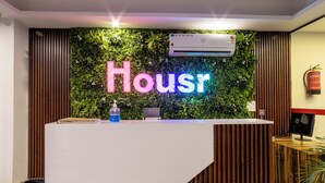 Una recepción con un letrero de neón que dice 'Houst' y una unidad de aire acondicionado arriba.