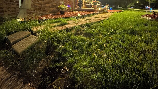 Una casa in mattoni con un portico luminoso e un giardino antistante.
